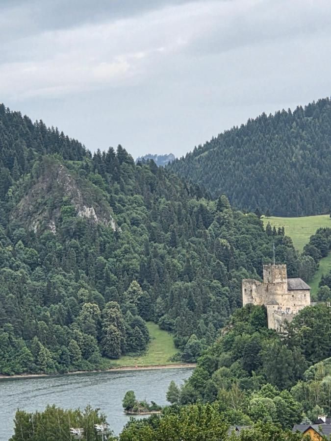 Zamek w Niedzicy na zalesionym wzgórzu nad jeziorem